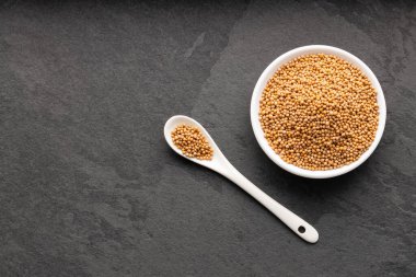 Sinapis alba - Sarı hardal tohumları kaşık ve kase.