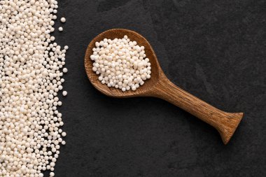 Kasava kökünden Tapioca incileri kaşıkta beyaz sagu topları. Manihot esculenta.