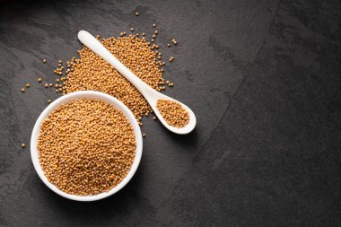 Sarı hardal tohumları kasede ve kaşıkta - Sinapis alba