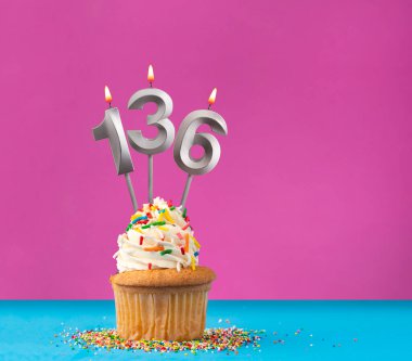 136 numaralı doğum günü mumunu yak - Menekşe ve mavi arka planda kutlama kartı