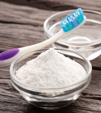 Diş fırçası, kabartma tozu ve sirke - ahşap arka plan.