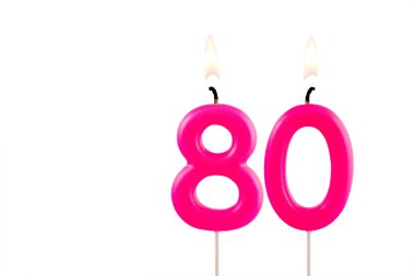 Pembe numara 80 doğum günü mumu beyaz arka planda yanıyor