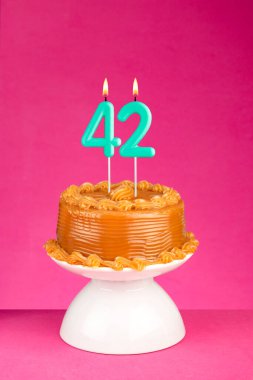 42 numaralı mumlu doğum günü pastası - Pembe arka planda yıldönümü kartı