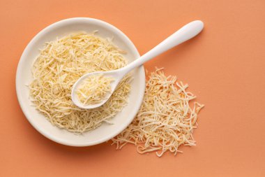 Kase ve kaşıkta kurutulmuş şeker ile rendelenmiş hindistan cevizi..