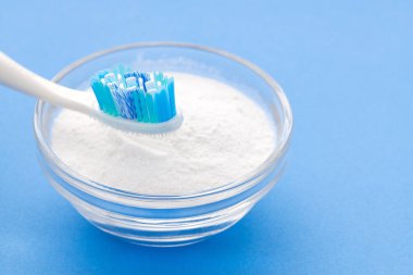 Evde temizlik için diş fırçası ve kabartma tozu - mavi arkaplan.