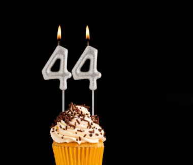44 numara şekilli mumlar - Siyah arkaplanda doğum günü pastası.