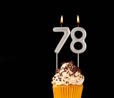 78 numara şekilli mumlar - Siyah arkaplanda doğum günü pastası.