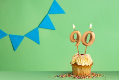 90 numaralı mumlu doğum günü keki - mavi flama ile yeşil arkaplan.