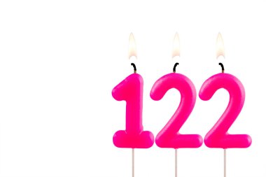 Pembe numara 122. Doğum günü mumu beyaz arka planda yanıyor.