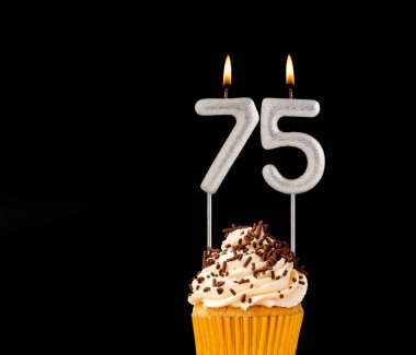 Siyah arkaplanda doğum günü pastası - 75 numara mumlar.