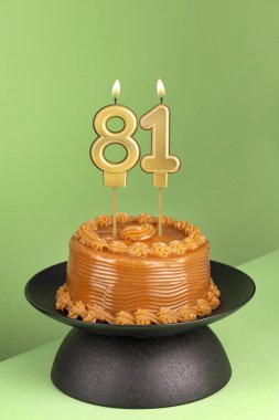 Yeşil arka planda 81 numaralı doğum günü mumu.
