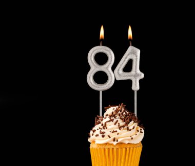 84 numara mumlar - Siyah arkaplanda doğum günü pastası.