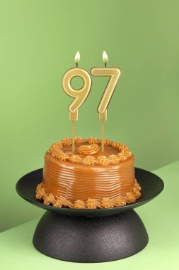 Yeşil arka planda 97 numaralı doğum günü mumu.