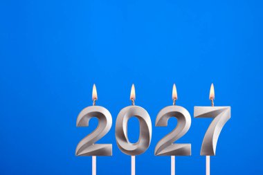 Mutlu yıllar için 2027 numaralı mum - Mavi arka planda yeni yıl kutlaması