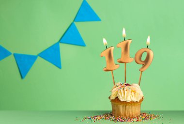 119 numaralı mumlu doğum günü kartı mavi flama ile yeşil arka planda kek..