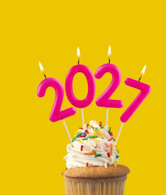 Mutlu yıllar için 2027 numaralı mum - Sarı arka planda yeni yıl arifesi kutlaması
