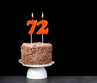 72 numaralı mumlu doğum günü kartı - Siyah arka planda çikolatalı pasta.
