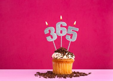 365 sayısını oluşturan üç mum - pembe arkaplan.