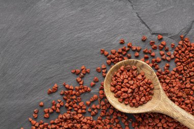 Kırmızı organik annatto tohumları kaşıkta - Bixa Orellana.