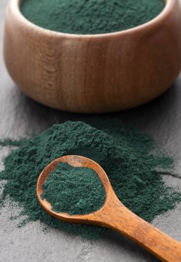 Kâse ve kaşıkta organik spirulina tozu - sağlıklı yiyecek.