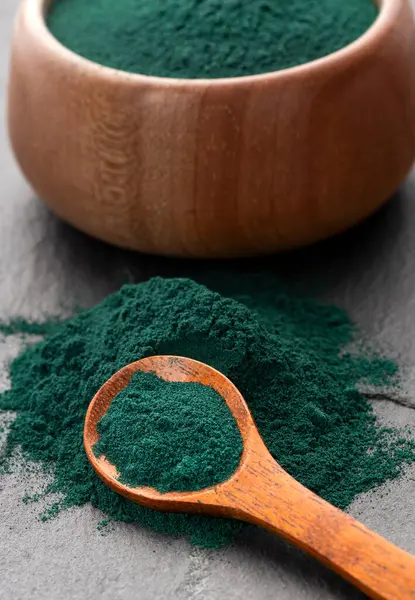 Kâse ve kaşıkta organik spirulina tozu - sağlıklı yiyecek.