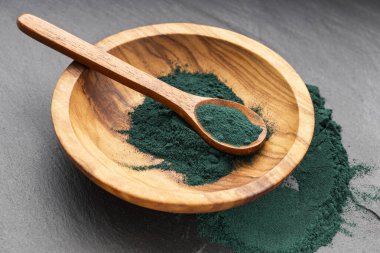 Kâse ve kaşıkta organik spirulina tozu - sağlıklı yiyecek.