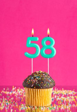 Kekli doğum günü kartı ve 58 numaralı mum - Pembe arka plan.