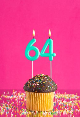 Kek ve 64 numaralı mumlu doğum günü kartı - Pembe zemin.