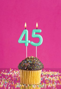 45 numaralı mumlu doğum günü keki fuşya arka planında kutlama kartı.