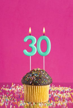 Kekli doğum günü kartı ve 30 numaralı mum - Pembe arka plan.