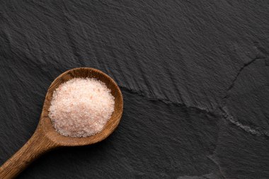 Kaşık üzerinde ince tuz ve pembe Himalaya kristalleri.