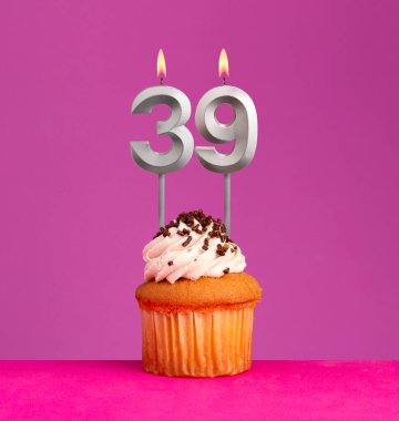 Doğum günü mumu 39 numara, menekşe arkaplanda kek..