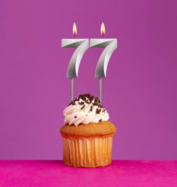 77 numaralı doğum günü mumu ve menekşeli kek..