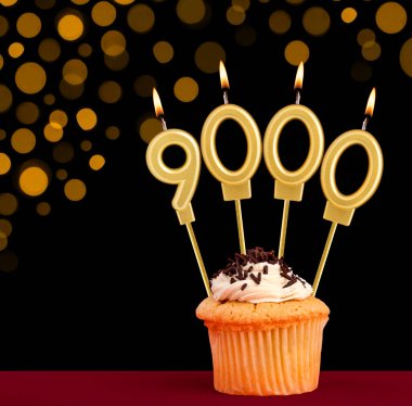 9000 numaralı doğum günü mumu - Siyah arkaplanlı ve odak ışıkları olmayan kek