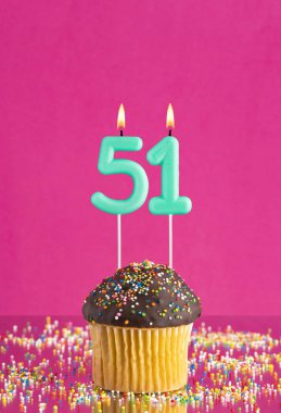 51 numaralı mumlu doğum günü keki fuşya arka planında kutlama kartı.