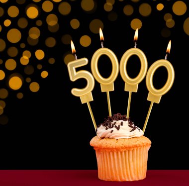 5.000 numaralı doğum günü mumu - Siyah arkaplanlı ve odak ışıkları olmayan kek