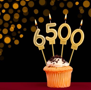 Kekli doğum günü mumu - 6500 numaralı odak ışıkları kapalı siyah arka plan