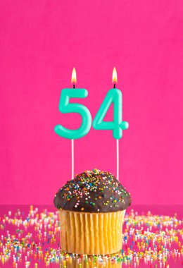 Kekli doğum günü kartı ve 54 numaralı mum - Pembe arka plan.
