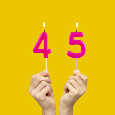 45 numaralı doğum günü - Eller fuşya renkli mumlar tutuyordu