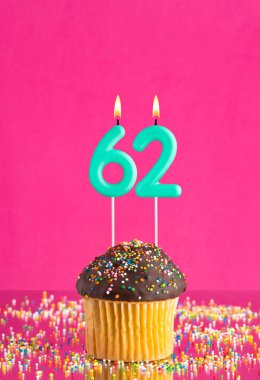 Kekli doğum günü kartı ve 62 numaralı mum - Pembe arka plan.