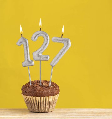 127 numaralı doğum günü mumu - Sarı arka planda çikolatalı kek