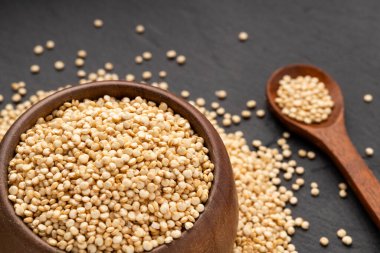 Kaşık ve kâse içinde çiğ beyaz kinoa tohumları - Chenopodium kinoa