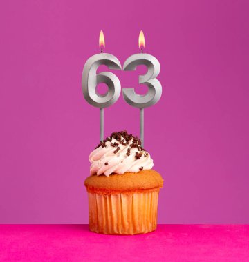 63 numaralı doğum günü mumu ve menekşeli kek..
