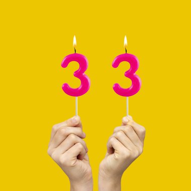 33 numaralı doğum günü - Eller fuşya renkli mumlar tutuyordu