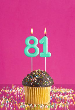 81 numaralı mumlu doğum günü keki fuşya arka planında kutlama kartı