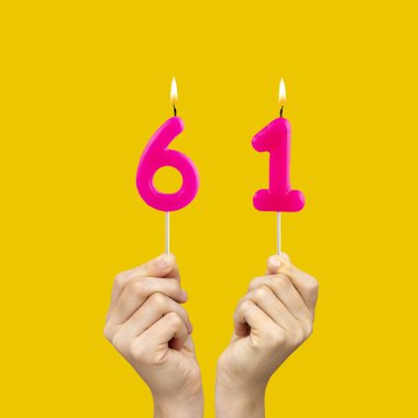 61 numaralı doğum günü - Eller fuşya renkli mumları tutuyor