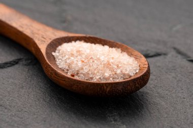 Kaşık içinde pembe Himalaya tuzu - ince kristaller serpiştirilmiş.