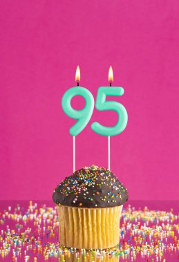 95 numaralı mumlu doğum günü keki fuşya arka planında kutlama kartı