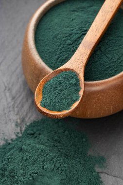 Kâse ve kaşıkta organik yeşil spirulina tozu - besin takviyesi.