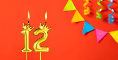 12 numaralı mum - Turuncu arka planda flama ile doğum günü kutlaması